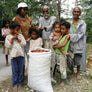 In Timor a farmers an a family gather around a large bag of coffee cherries