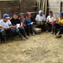 Cooperative members having a meeting in a dirt floored room