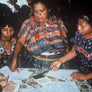 Guatemalan women stamping forms around a table
