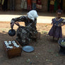 Ethiopian women roasting and pouring coffee; a young girl looks on