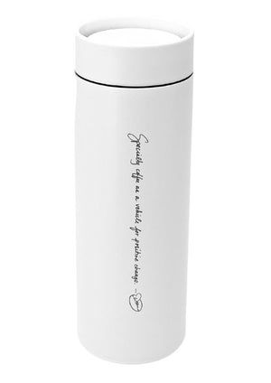 A tall, white MiiR travel mug with a screw on flip top and engraved with "Specialty coffee as a vehicle for positive change" and Dean's signature bean