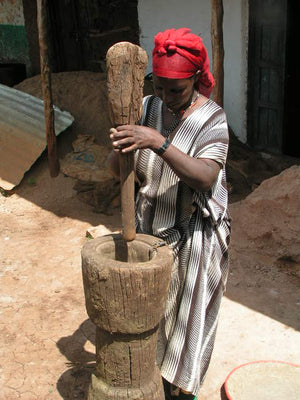 Ethiopian woman using a large mortar and pestle