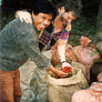 Young Dean and a farmer pulling handfuls of coffee cherries out of a bag