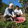 Dean and a farmer with a basket of coffee cherries