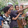 A group of women and children showing off their coffee cherries