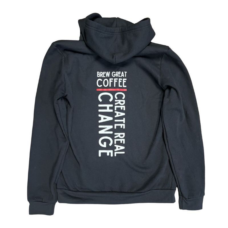 the back of a black hooded sweatshirt  with text that reads "brew great coffee create real change"