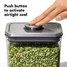 the silver lid of the canister has a button that you press to activate an airtight seal