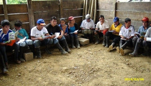 Cooperative members having a meeting in a dirt floored room