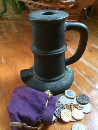 A thunder mug and a small, purple bag with pirates booty spilling out 